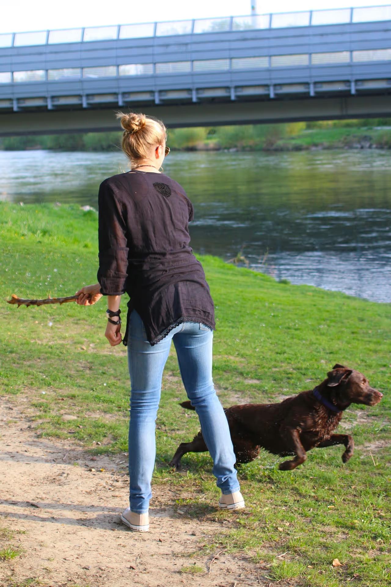 Frau spielt mit ihrem Hund im Freien